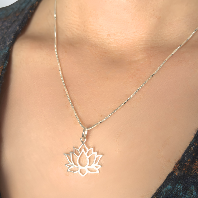 Load image into Gallery viewer, Silver lotus flower necklace on a person wearing a dark blue top.
