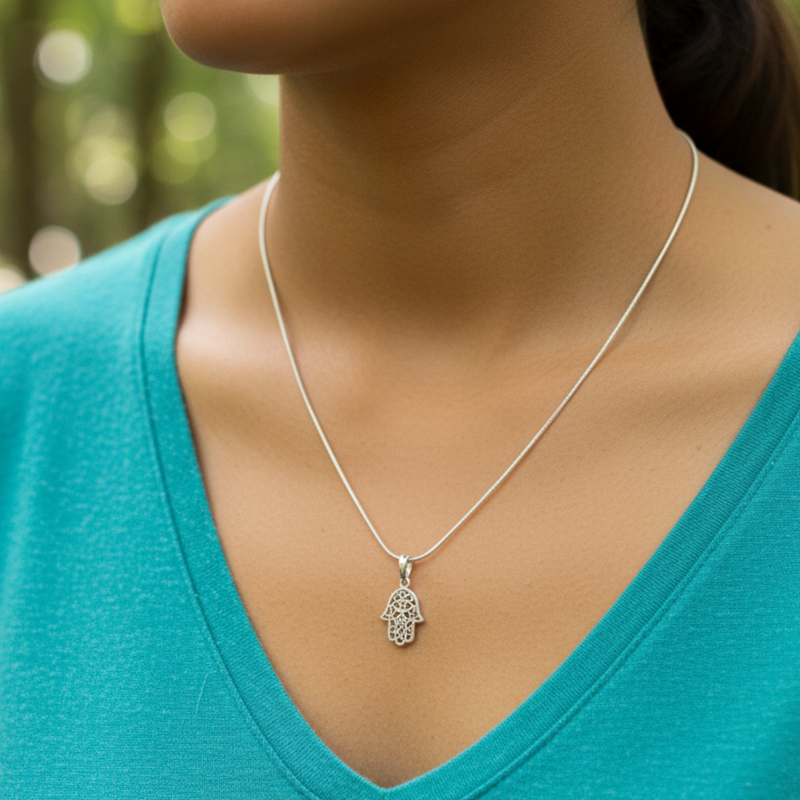 Load image into Gallery viewer, Silver necklace with a pendant worn by a person in a teal shirt against a blurred natural background
