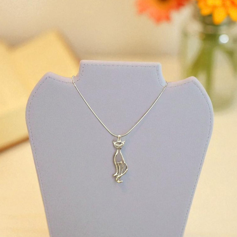 Load image into Gallery viewer, Silver necklace on a gray stand with orange flowers in the background
