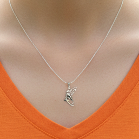 Silver fairy pendant necklace on a person wearing an orange top.