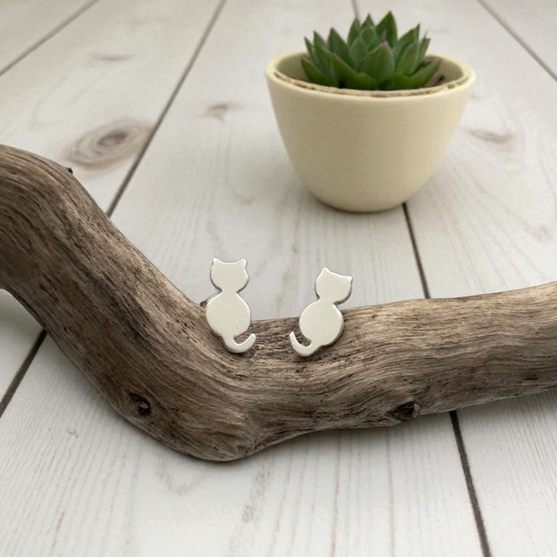 Load image into Gallery viewer, Cat-shaped earrings on a wooden surface with a small plant in the background

