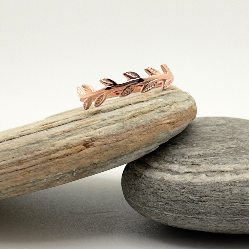Load image into Gallery viewer, Rose gold leaf-shaped ring on a stack of stones with a neutral background
