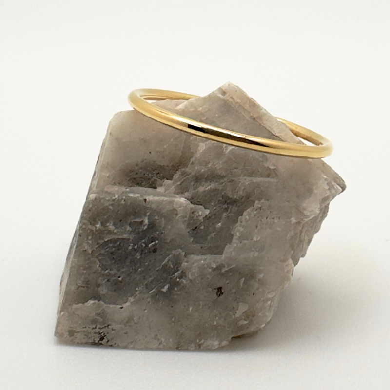 Load image into Gallery viewer, Gold ring on a piece of gray stone against a white background
