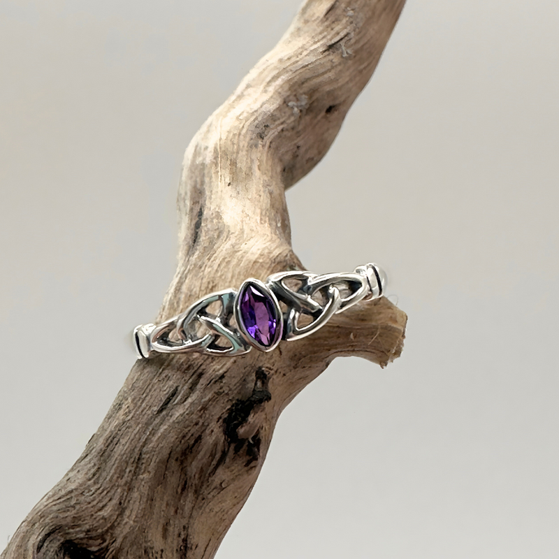 Load image into Gallery viewer, Silver ring with a purple gemstone on a piece of driftwood against a light background
