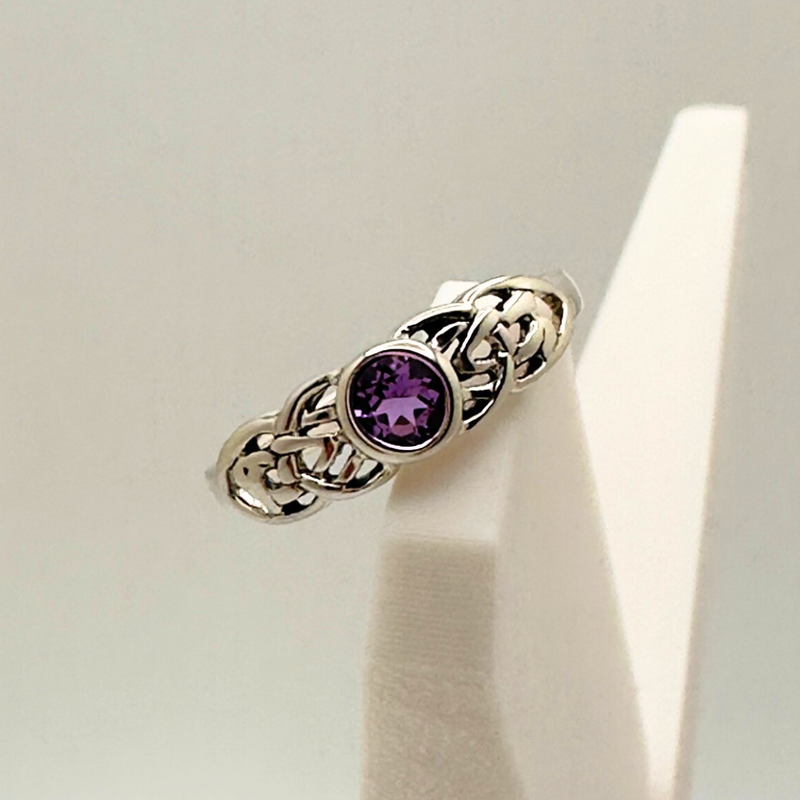 Load image into Gallery viewer, Silver ring with a purple gemstone on a white stand

