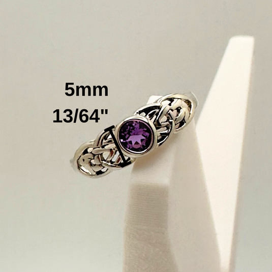 Silver ring with a purple gemstone on a white stand, showing size measurement.