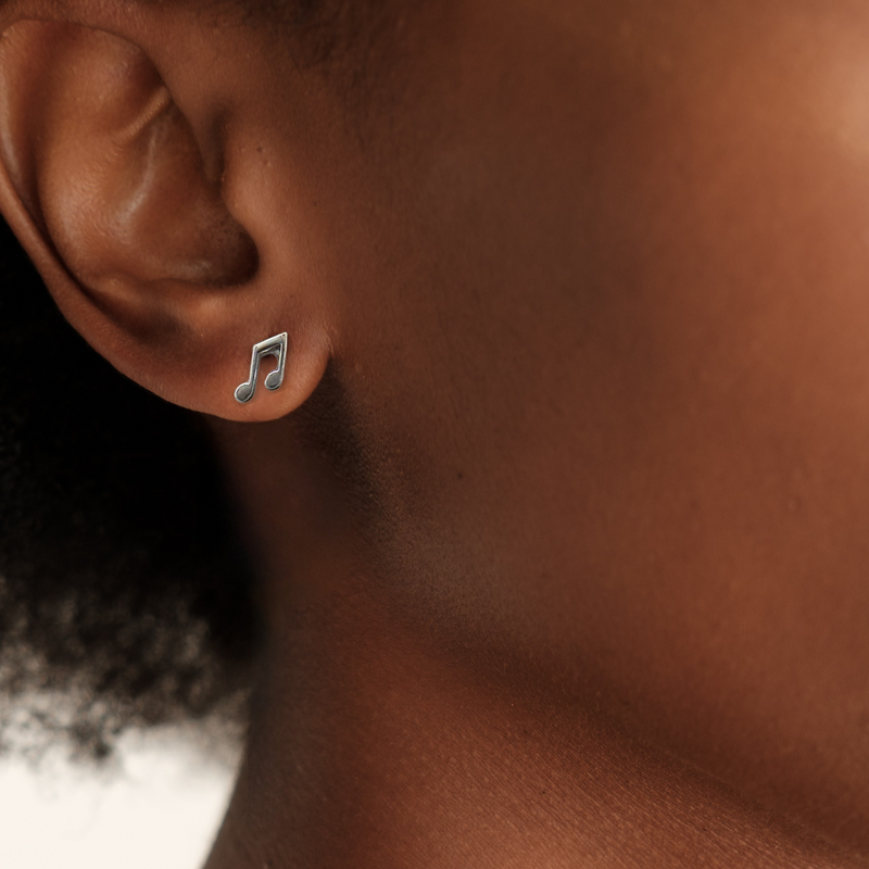 Load image into Gallery viewer, Close-up of an ear wearing a music note earring with a blurred background
