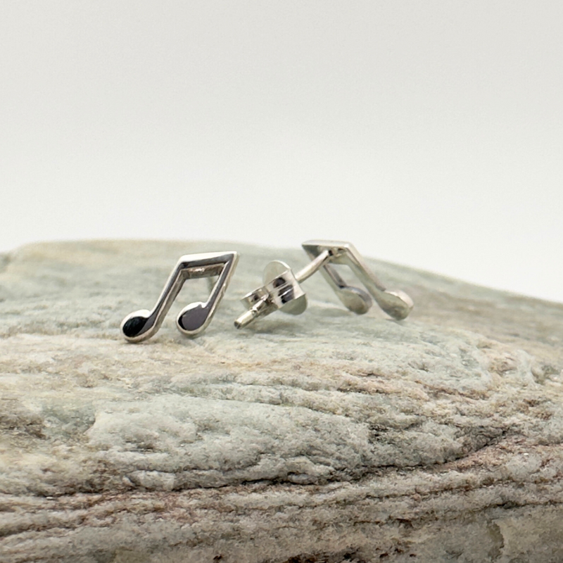Load image into Gallery viewer, Silver music note earrings on a stone surface
