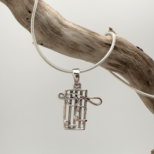 Silver pendant on a chain against a neutral background