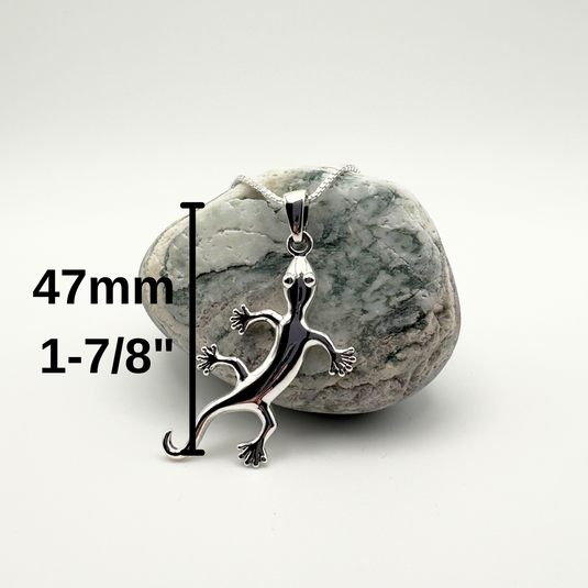 Silver lizard pendant on a rock with measurement text