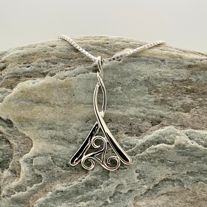 Load image into Gallery viewer, Silver pendant on a stone surface
