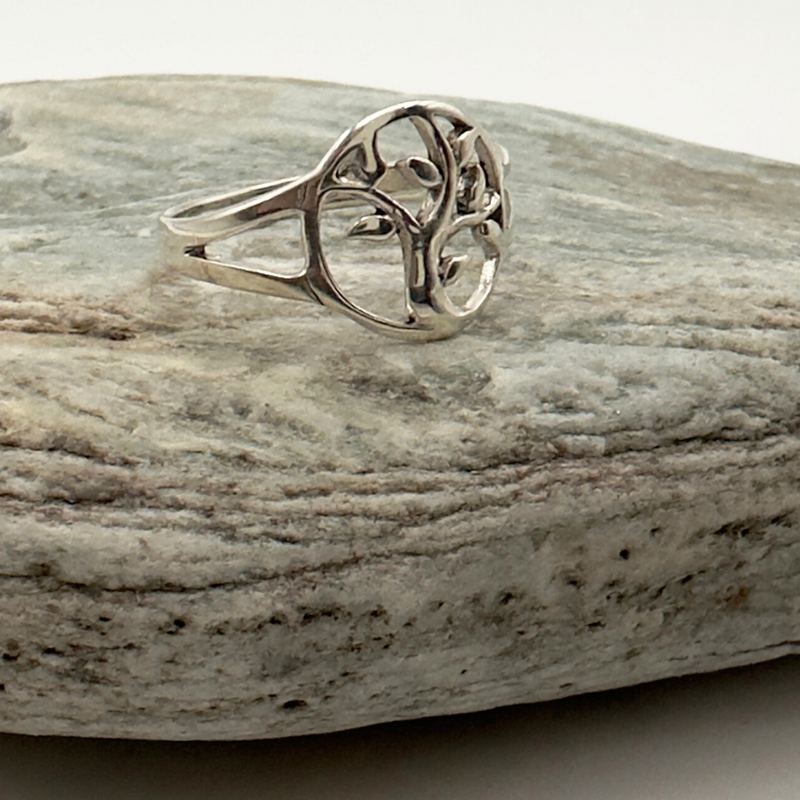 Load image into Gallery viewer, Silver ring with a tree design on a gray stone surface
