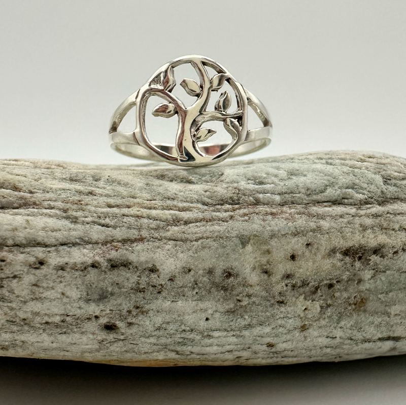 Load image into Gallery viewer, Silver ring with a tree design on a piece of driftwood against a light background
