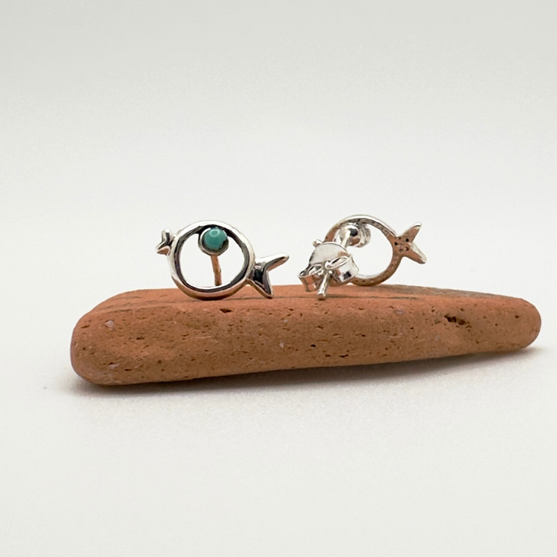 Load image into Gallery viewer, Two silver earrings with turquoise stones on a piece of driftwood against a white background
