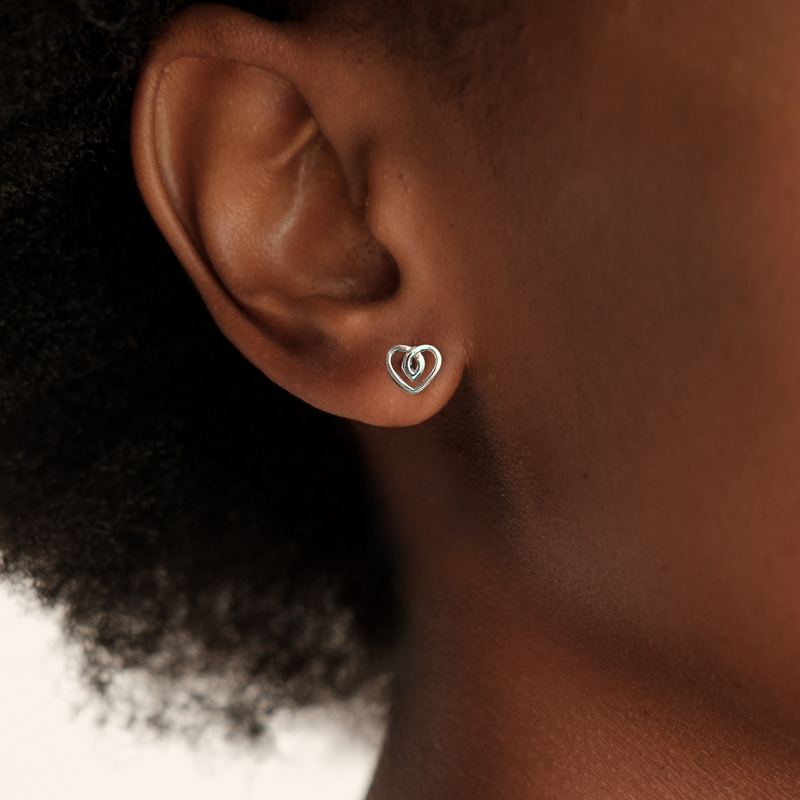 Load image into Gallery viewer, Heart-shaped earring worn by a person with a neutral background
