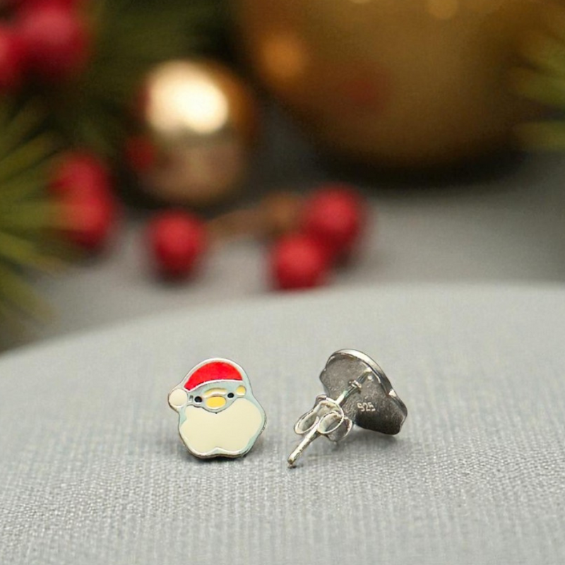 Load image into Gallery viewer, Christmas-themed earrings with a Santa Claus design on a gray surface with blurred festive background.
