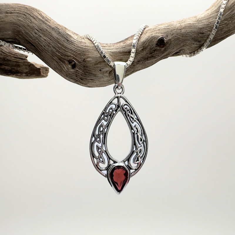 Load image into Gallery viewer, Silver pendant with a red stone on a chain, hanging from a branch against a white background
