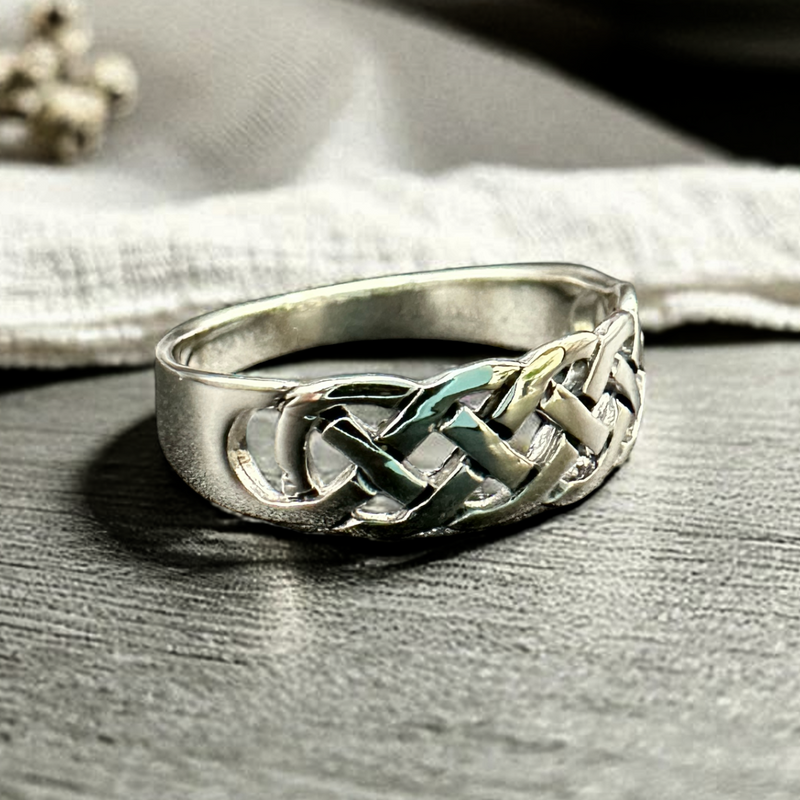 Load image into Gallery viewer, Silver ring with a braided design on a wooden surface
