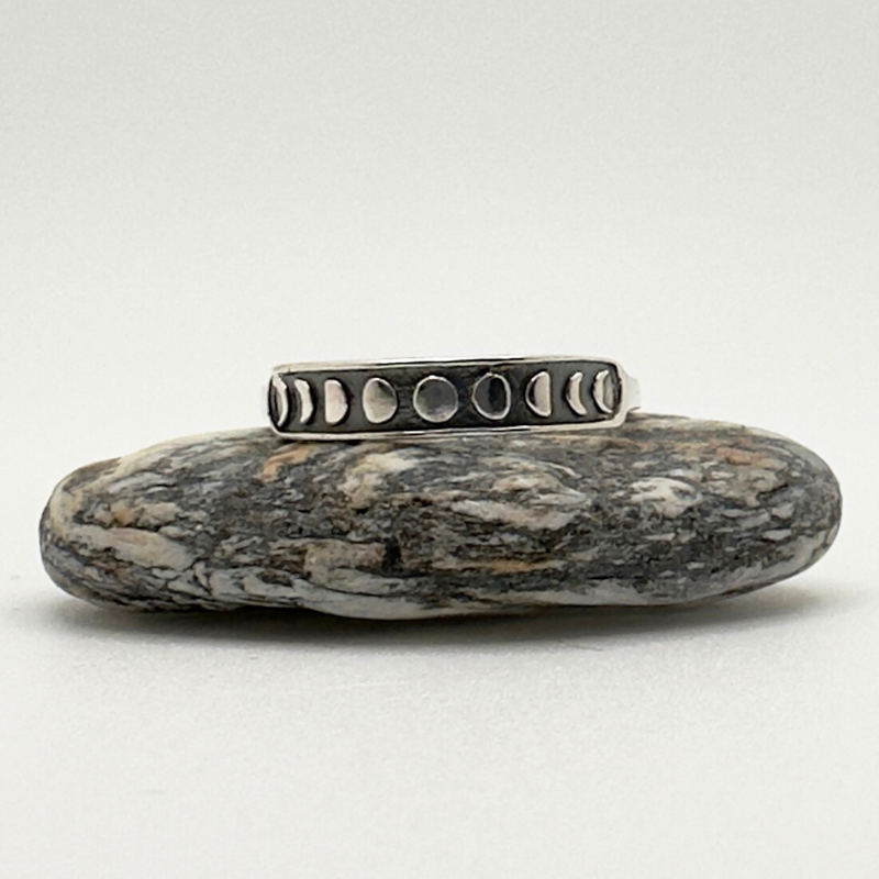 Load image into Gallery viewer, Silver ring with small stones on a textured stone surface

