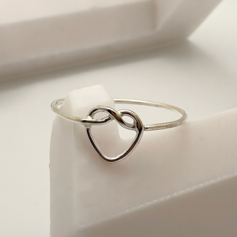 Load image into Gallery viewer, Silver heart-shaped ring on a white surface
