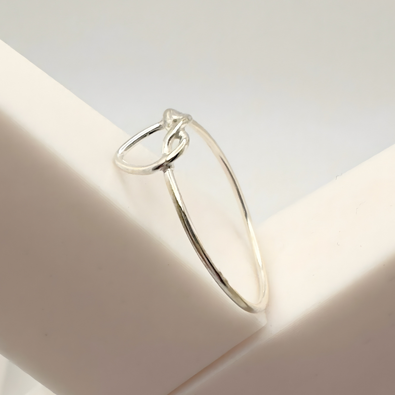 Load image into Gallery viewer, Silver ring on a white surface with a soft focus background
