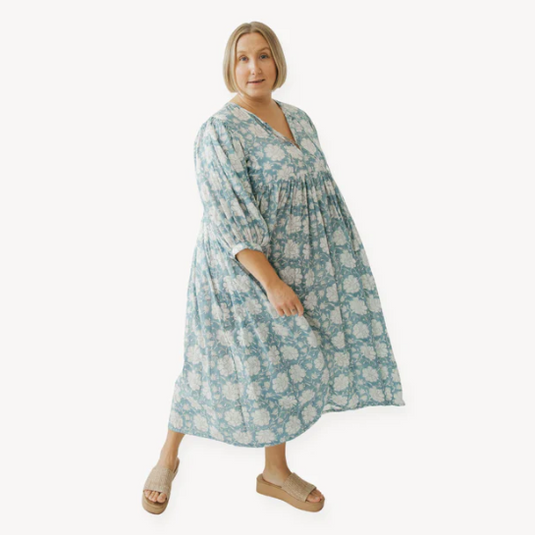 Woman wearing a blue floral dress on a white background